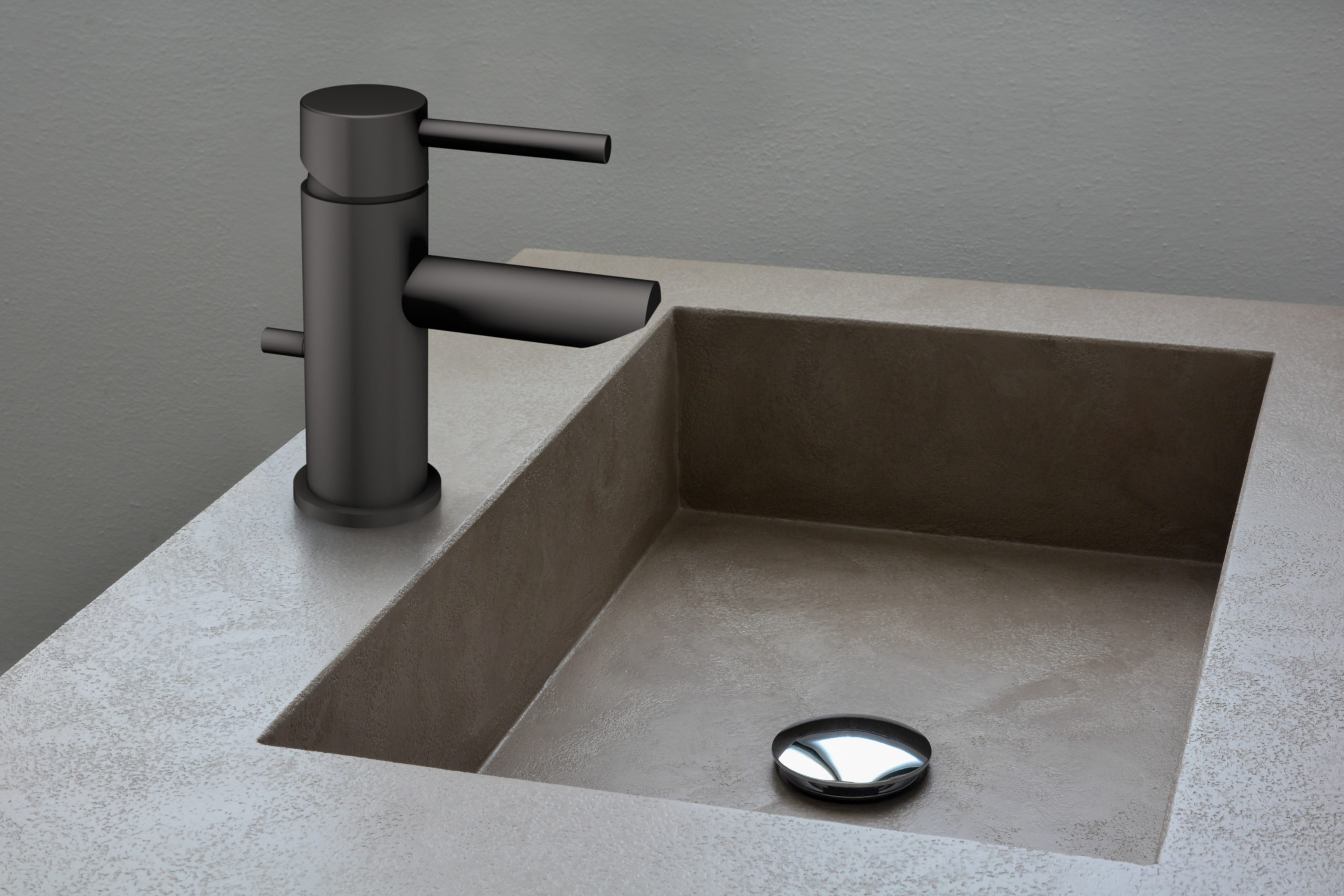 A matte black, single-handle bathroom faucet with a dark brown concrete sink.