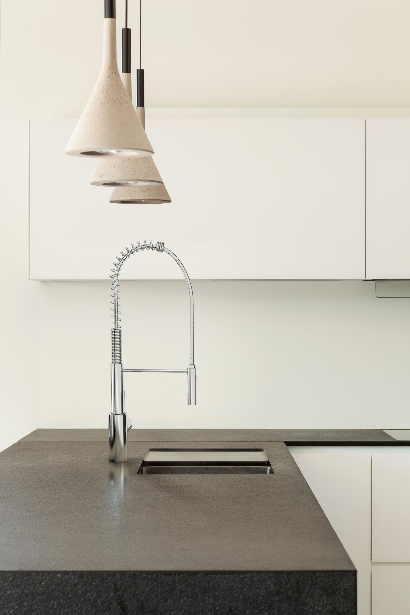 Kitchen with light cabinets and dark brown granite countertop, complemented with a pre-rinse style faucet.